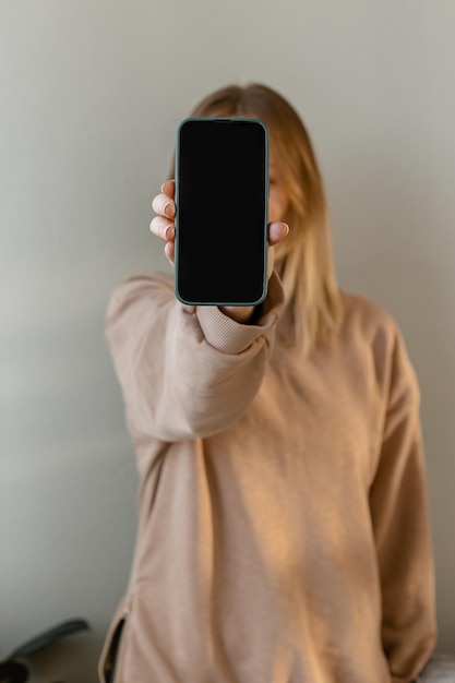 Het meisje houdt een telefoon vast Plaats voor tekst