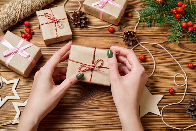 Het meisje houdt in haar hand een geschenkdoos op de achtergrond van kerstaccessoires