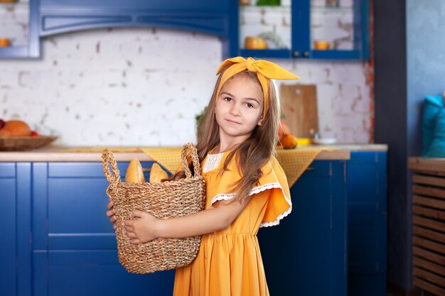 Het meisje houdt mand brood. Het meisje houdt mand met brood op keuken. Mand met brood. Bakkerijproducten in een mand thuis. Herfst keuken inrichting. interieur rustiek.