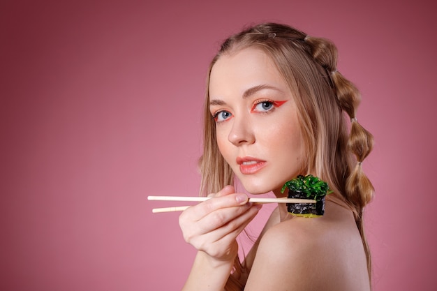 Het meisje houdt sushistokken op haar schouder