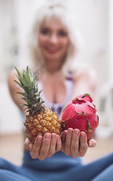 Het meisje in de sportschool houdt exotisch fruit in haar handen