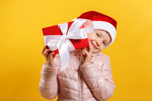 Het meisje in santahoed houdt kerstmisgift.