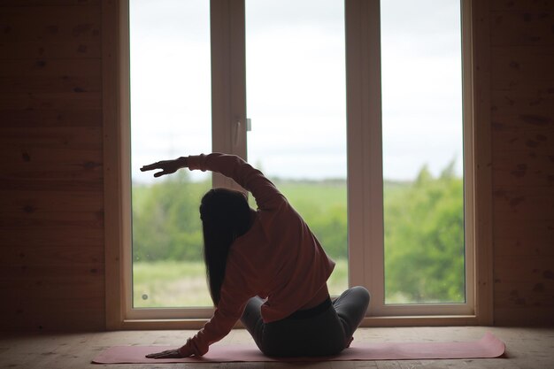 Het meisje in yoga op het tapijt