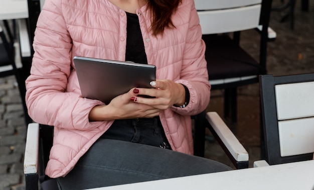 Het meisje is een tiener In haar handen houdt een tablet. Hij kijkt naar sociale netwerken.