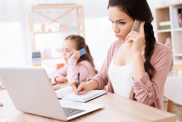 Het meisje kopieert thuis Mamma met Telefoon ter beschikking.