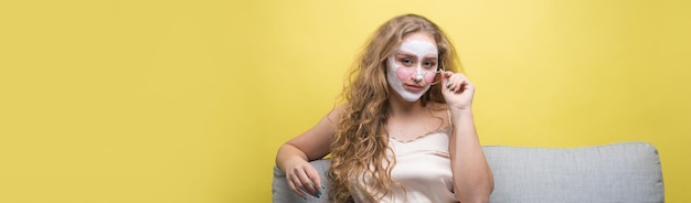 Het meisje maakt procedures met een cosmetisch masker op haar gezicht