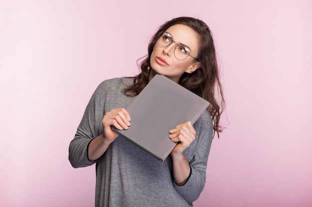 Het meisje met een boek op roze achtergrond