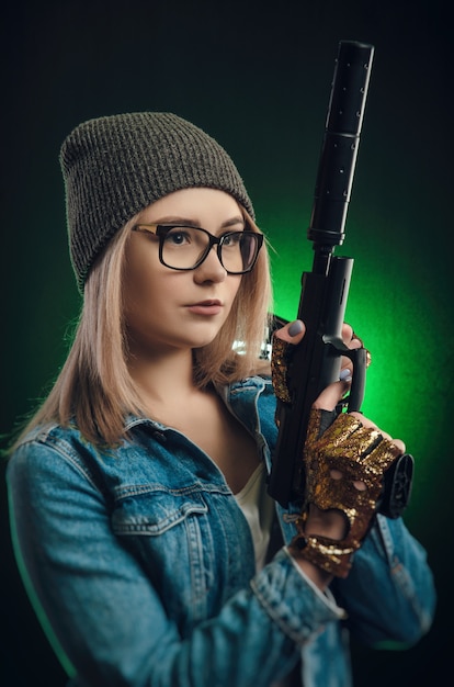 Het meisje met een pistool poseren op een zwarte achtergrond (sniper scope)
