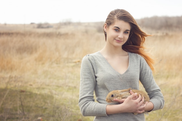 Het meisje met het konijn. Gelukkig meisje die leuk pluizig Konijntje houden