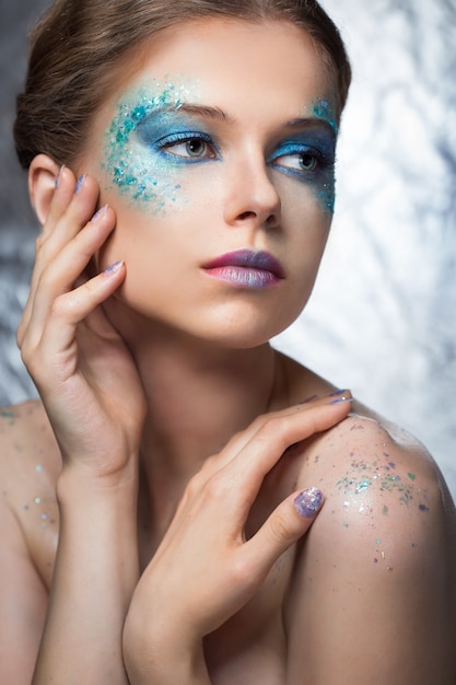 Het meisje met lichte fashion make-up en glitters