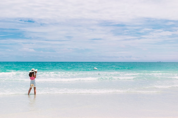 Het meisje op het strand. Toeristen nemen foto's voor hun plezier.