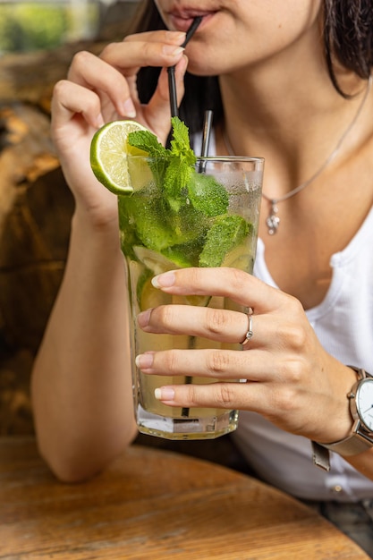 Het meisje proeft een cocktail in de restaurantbar