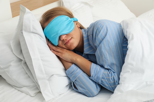 Het meisje slaapt in bed met een slaapmasker op