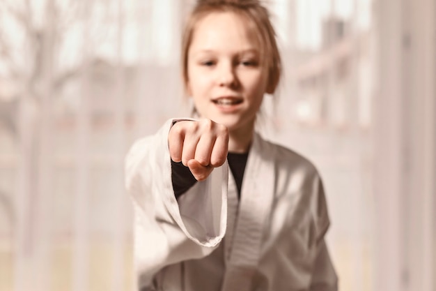 Het meisje slaat haar hand en kijkt naar de camera