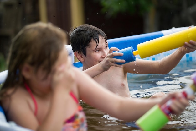 Het meisje sloot haar ogen en de jongen schiet in het zwembad op zomerdag