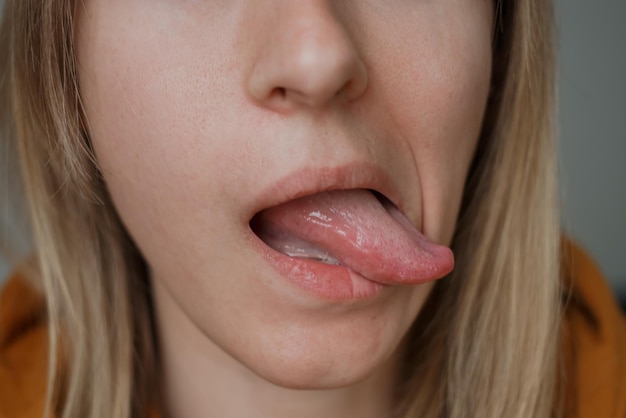 Het meisje toont haar tong gezichtsuitdrukkingenxA
