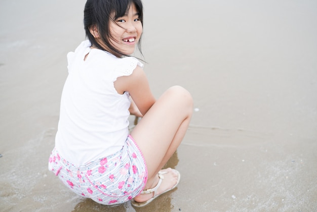 Het meisje van Azië het spelen op het strand haar glimlach