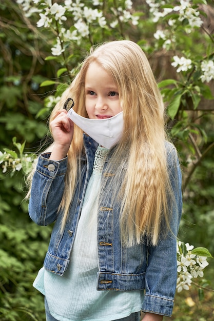 Het meisje verwijdert het medische masker aan het einde van de quarantaine