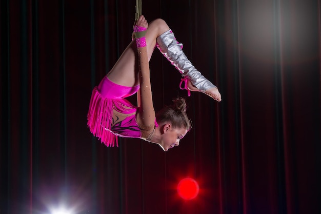 Het meisje voert acrobatische elementen uit in de lucht Circusturner op het podium