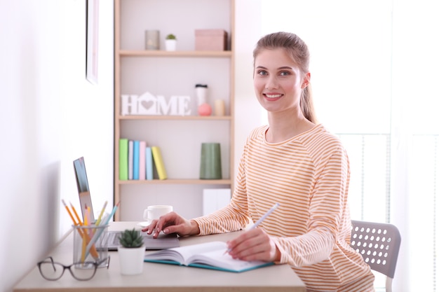 Het meisje werkt op afstand vanuit huis met een moderne laptop