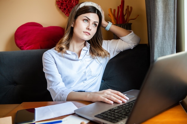 Het meisje werkt op de computer in een café. Freelancer die online werkt