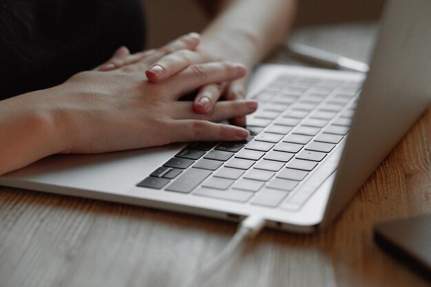 Het meisje werkt thuis voor een laptop Hand op de touchpad vinger klikt op informatie