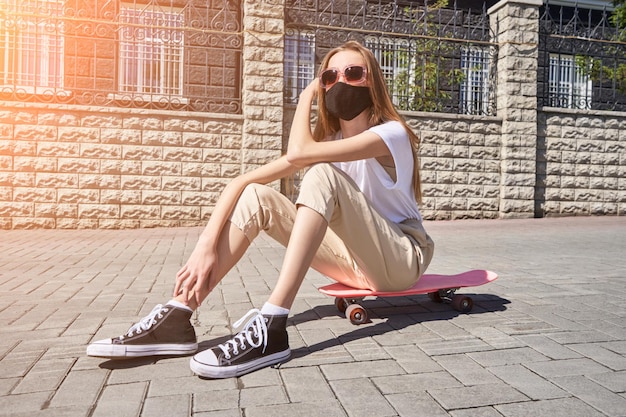 Het meisje zittend op skateboard Stadslandschap Herbruikbaar zwart gezichtsmasker