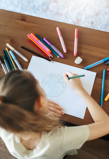 Het meisjestekening van het kind met kleurrijke potloden