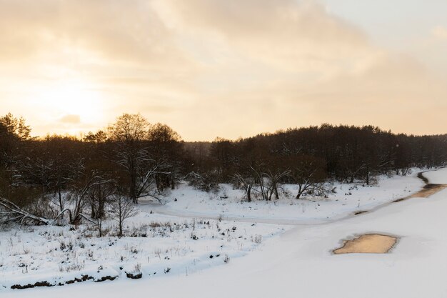 Het met ijs en sneeuw bedekte oppervlak van de rivier bij zonsondergang, bevroren in het winterseizoen