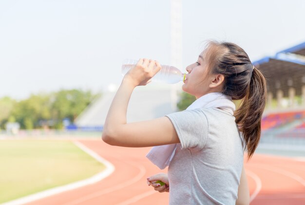 Het mooie Aziatische drinkwater van de atletenvrouw van fles