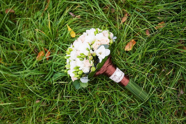 Foto het mooie boeket van huwelijksbloemen op het groene gras.