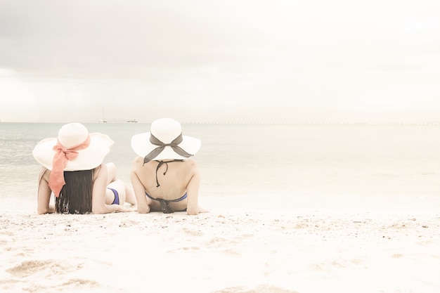 Het mooie Chinese vrouw ontspannen op wit zandstrand.