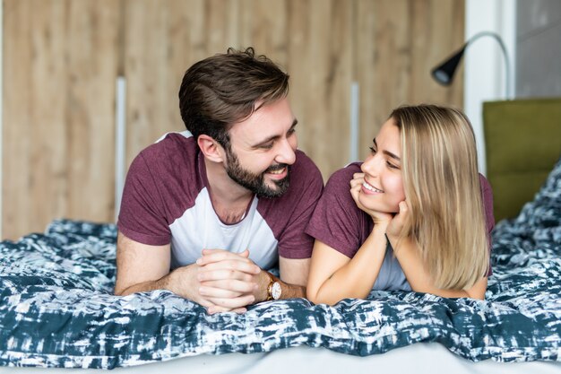 Het mooie jonge paar in slaapkamer ligt op bed. Samen tijd doorbrengen.