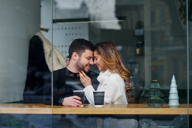 Het mooie Kaukasische paar in liefde drinkt koffie bij koffie. Liefde en romantisch.