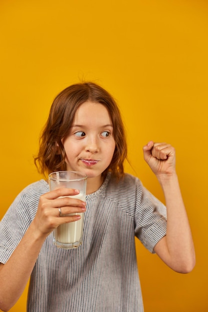 Het mooie kind van het tienermeisje met een vers glas melk