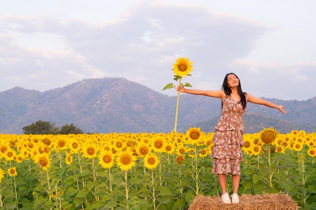 Het mooie meisje houdt zonnebloem vast met mooie ingediende bloem