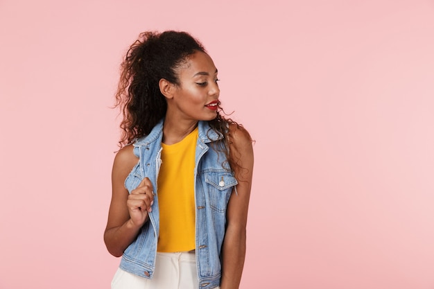 Het mooie verbazende jonge vrouw stellen geïsoleerd over roze muur