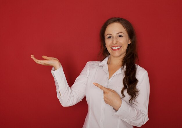 Het mooie vrouw tonen, die iets op de palm van haar hand voorstellen