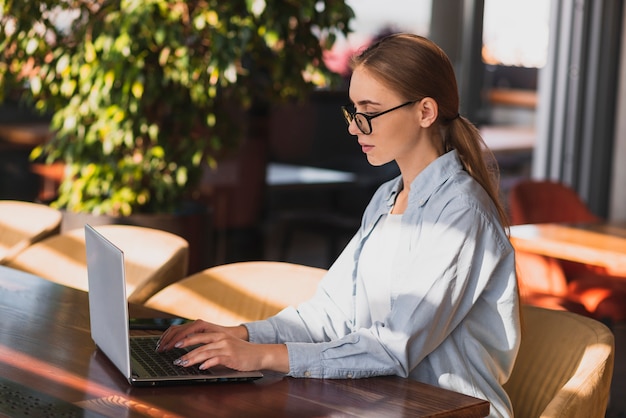 Het mooie vrouw typen op een laptop toetsenbord