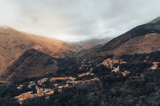 Het natuurlandschap met Marokkaanse atlasbergen met een klein dorpje eronder