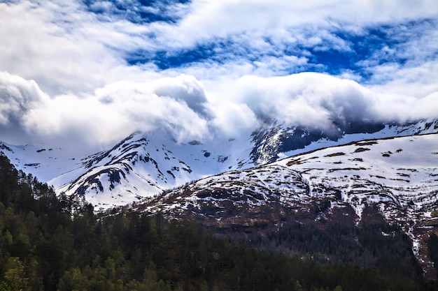 Het Noorse landschap: besneeuwde berg in wolken