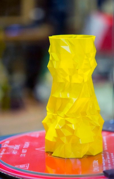 Het object in de vorm van een gele vaas staat op de desktop 3d-printer