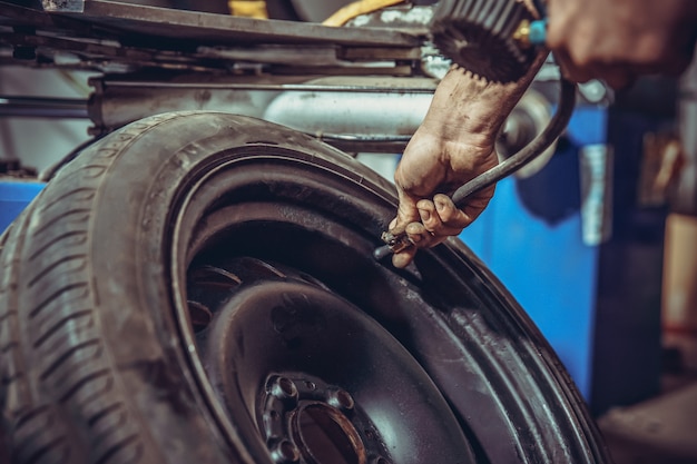 het onder druk zetten van de autoband bij een bandenservice