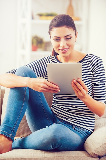 Het onderzoeken van haar gloednieuwe tablet. Mooie jonge vrouw die digitale tablet vasthoudt en ernaar kijkt