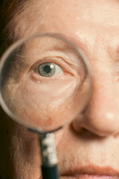 Foto het oog van een oude vrouw in een vergrootglas