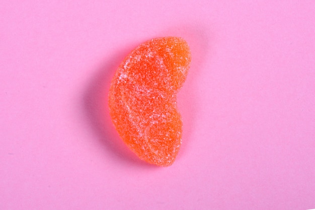 Het oranje suikergoed van de fruitgelei op roze