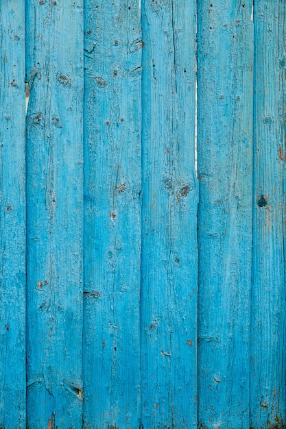 Het oude hek is een fragment van groene kleur, de verf pelt van het houten oppervlak af