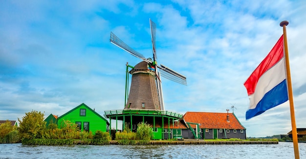 Het oude huis van de windmolen en de vlag van Nederland zijn populaire Nederlandse iconen Landschap panorama Amsterdam Holland Nederland