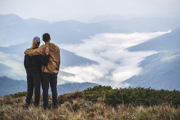 Het paar dat zich op de achtergrond van het berglandschap bevindt