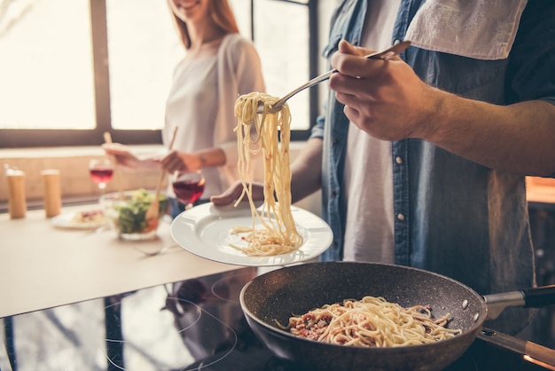 Het paar glimlacht terwijl het koken in de keuken.